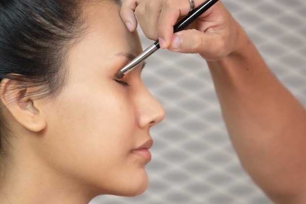 Photo cropped hand applying eyeshadow on woman