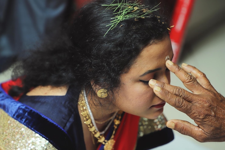 Photo cropped hand applying tilaka on woman forehead