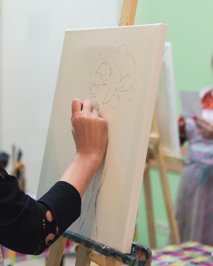 Photo cropped hand of artist drawing over canvas