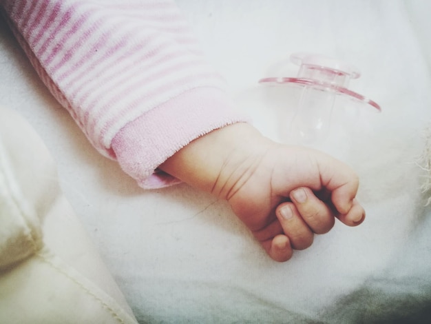 Foto la mano tagliata del bambino sul letto