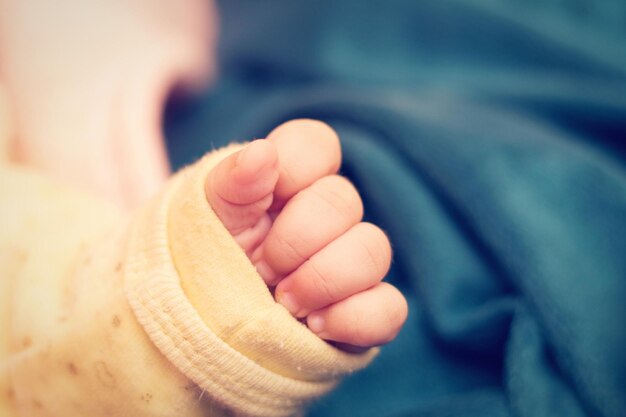 Photo cropped hand of baby on bed