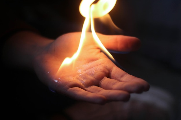 Foto una mano tagliata che brucia nella camera oscura.