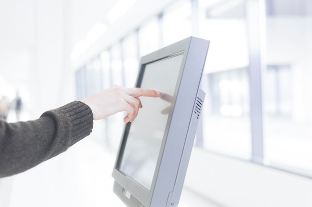 Photo cropped hand of business person touching computer monitor in office