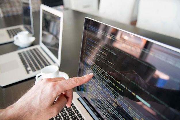 Photo cropped hand of businessman pointing on laptop in office