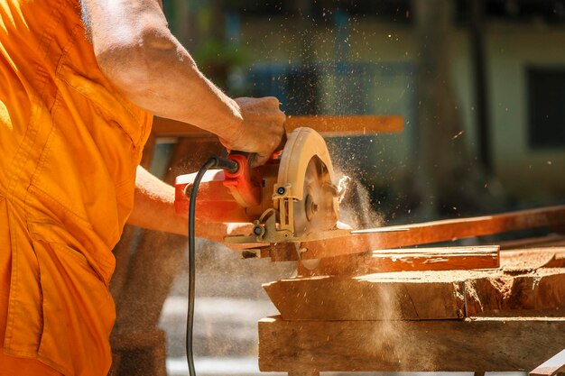 Cropped hand of carpenter cutting wood