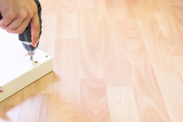 Photo cropped hand of carpenter drilling wood