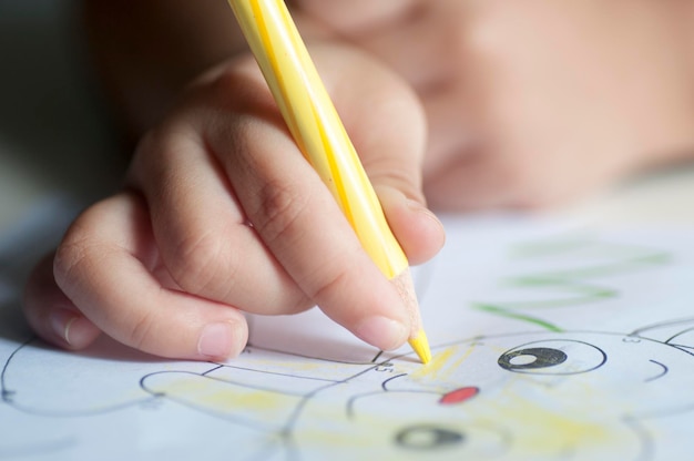 cropped hand of child coloring drawing