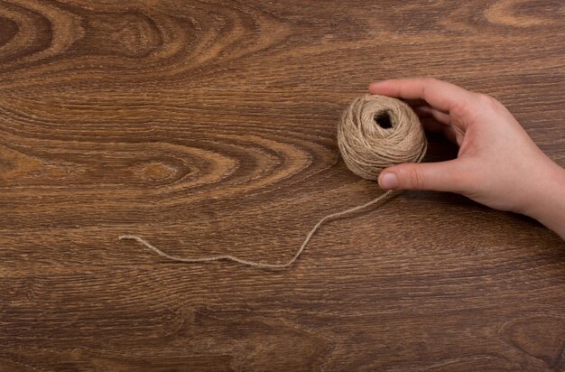 Cropped hand of child holding wool on table