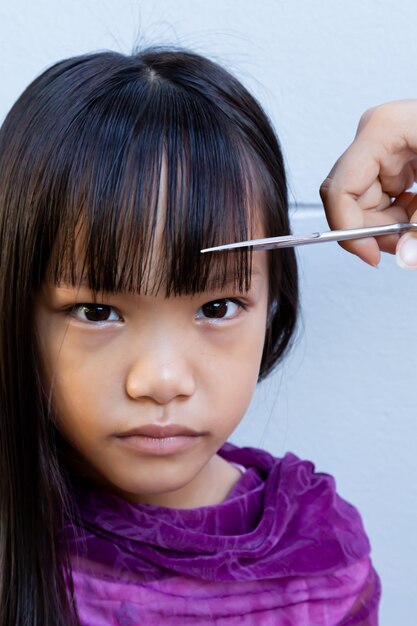 Cropped hand cutting girl hair