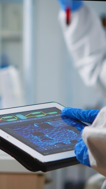 실험실 에서 디지털 태블릿 을 들고 있는 의사 의 절단 된 손