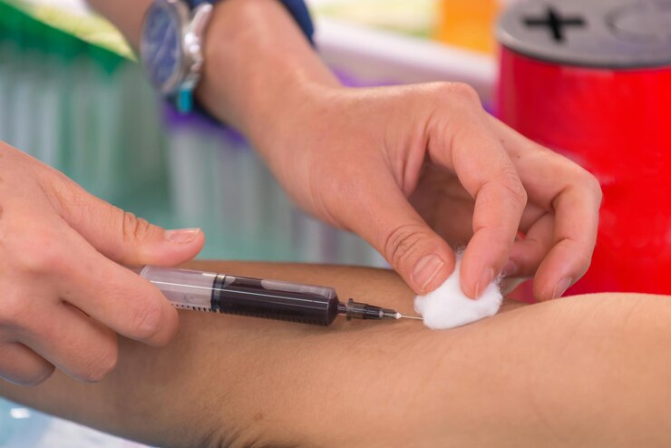 Photo cropped hand of doctor injecting patient in hospital