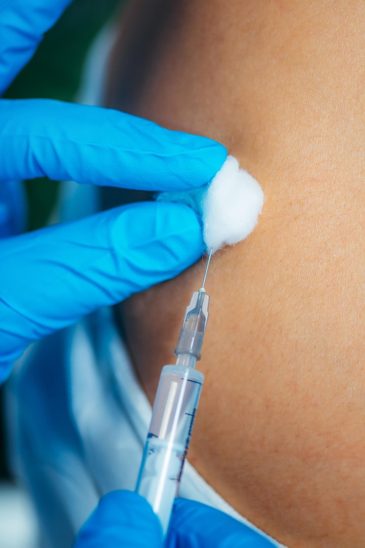 Photo cropped hand of doctor injecting patient