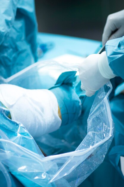 Cropped hand of doctor operating patient during knee surgery