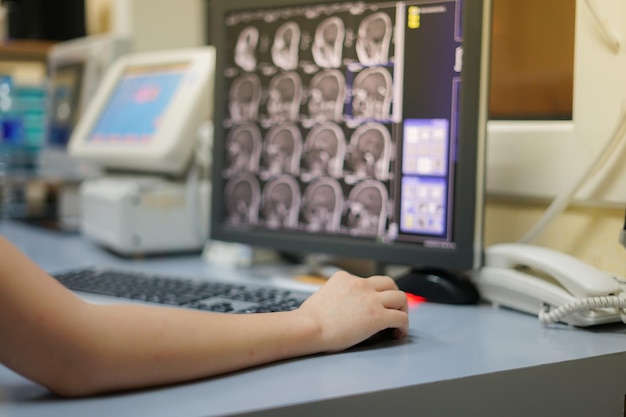 Foto mano tagliata di un medico che usa un computer al tavolo in ospedale