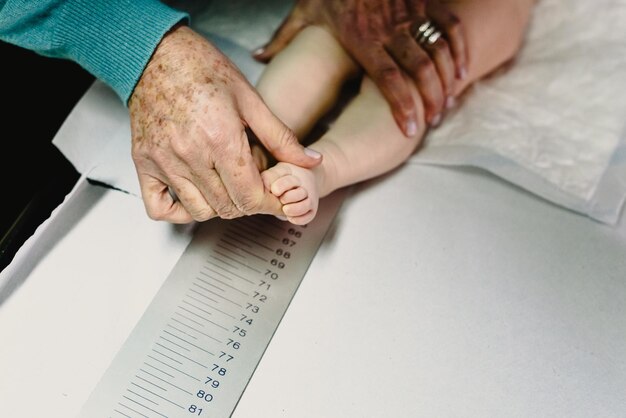 Photo cropped hand examining baby