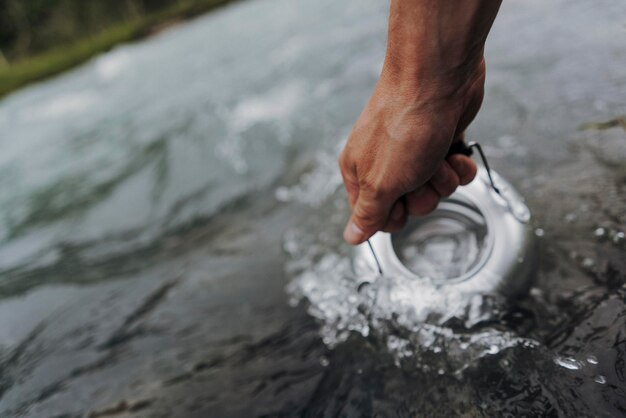 Cropped hand filling water in tea kettle