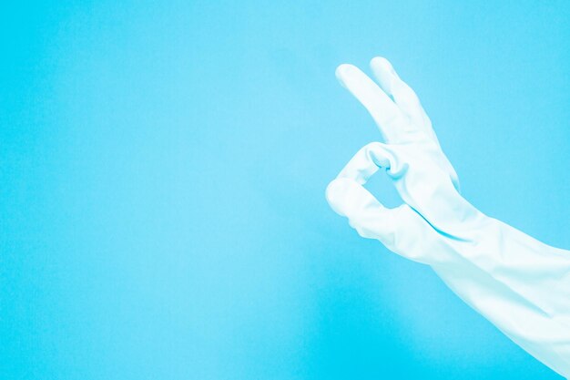 Cropped hand gesturing against blue background