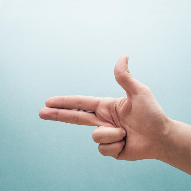 Photo cropped hand gesturing against turquoise background