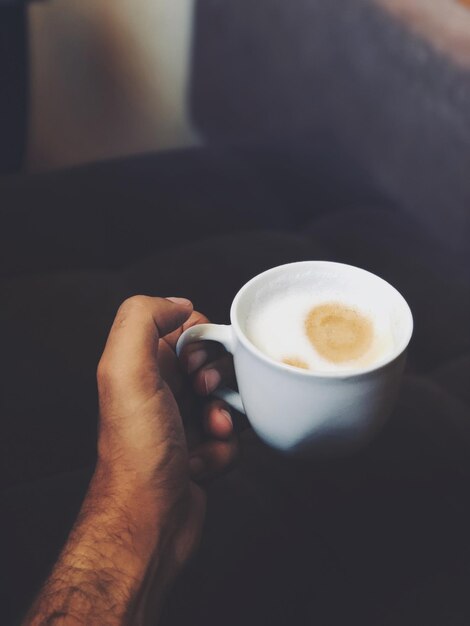 Cropped hand having coffee