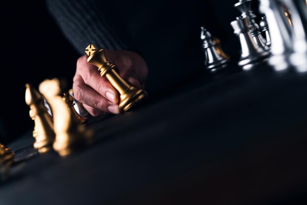 Foto mano tagliata che tiene un pezzo di scacchi sul tavolo