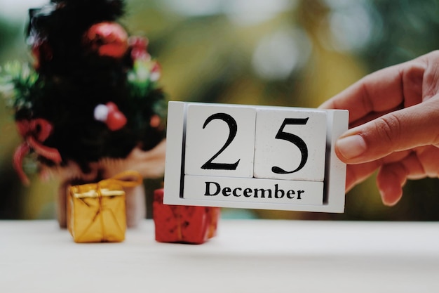 Cropped hand holding christmas decoration on table