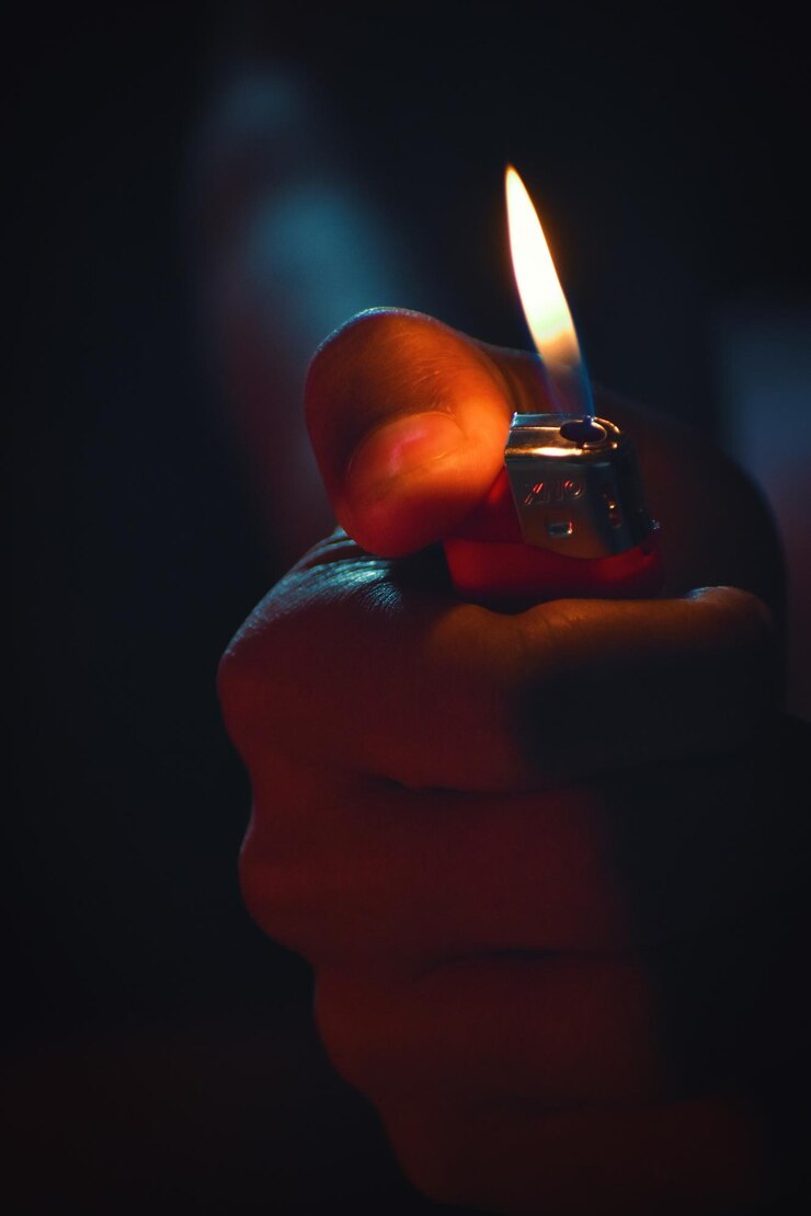 Photo cropped hand holding cigarette lighter