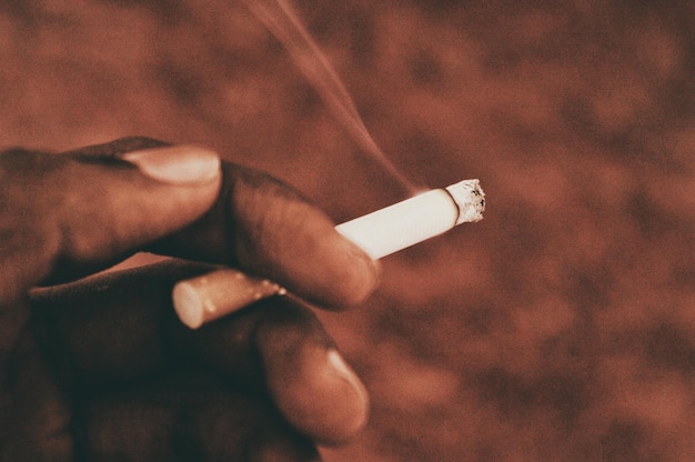 Photo cropped hand holding cigarette