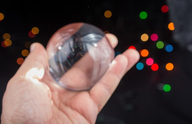 Cropped hand holding crystal ball at night