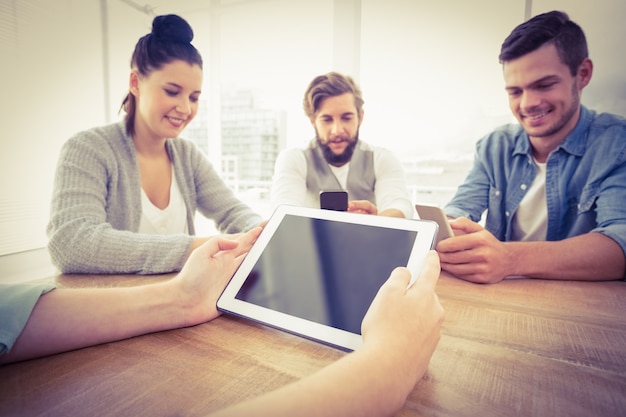 Cropped hand holding digital tablet with people using smartphones 