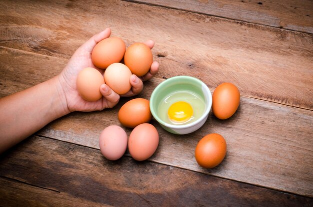 Cropped hand holding eggs on table