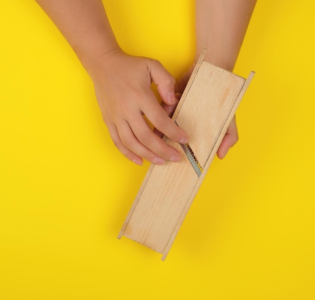 Photo cropped hand holding equipment on yellow background