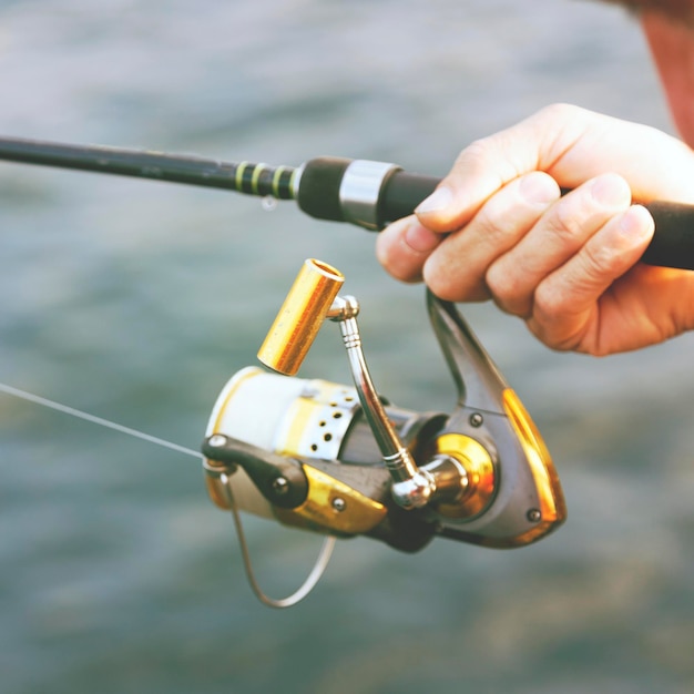 Photo cropped hand holding fishing rod