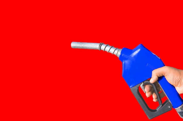 Photo cropped hand holding fuel pump against red background