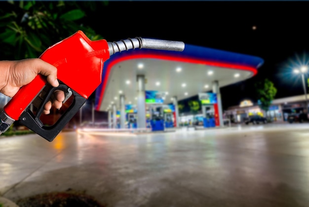 Photo cropped hand holding fuel pump at gas station