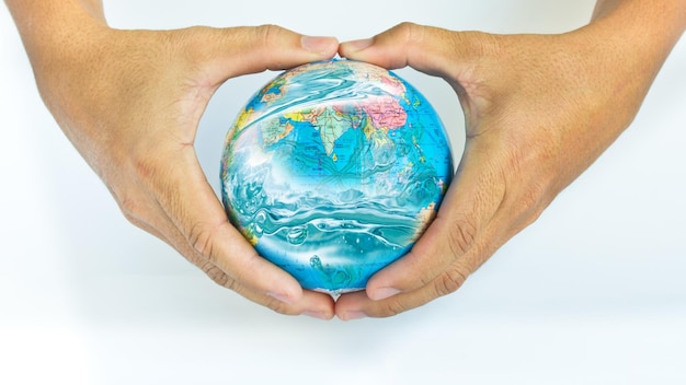 Photo cropped hand holding globe against blue background