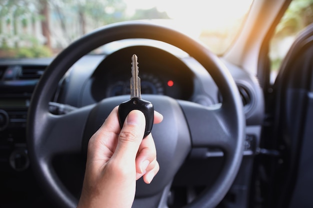 cropped hand holding key in car