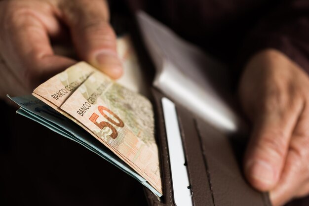 Photo cropped hand holding paper currency in purse