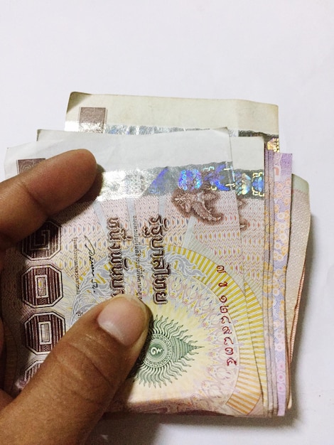 Photo cropped hand holding paper currency on table