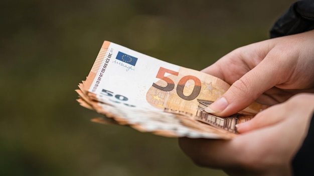 cropped hand holding paper currency