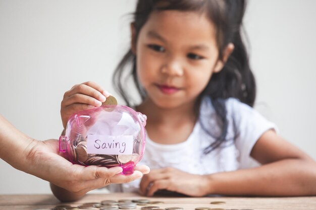 Photo cropped hand holding piggy bank for girl