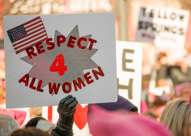 Photo cropped hand holding placard with text during protest in city