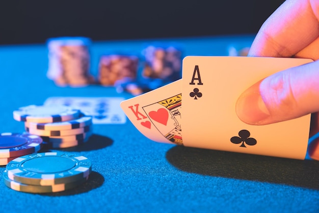 Cropped hand holding playing card over table