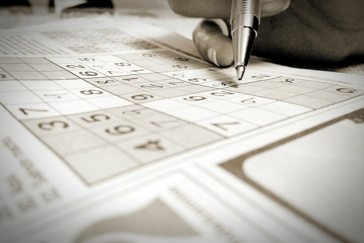 Photo cropped hand holding playing sudoku