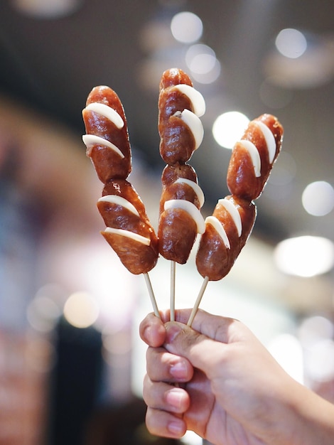 cropped of hand holding sausages