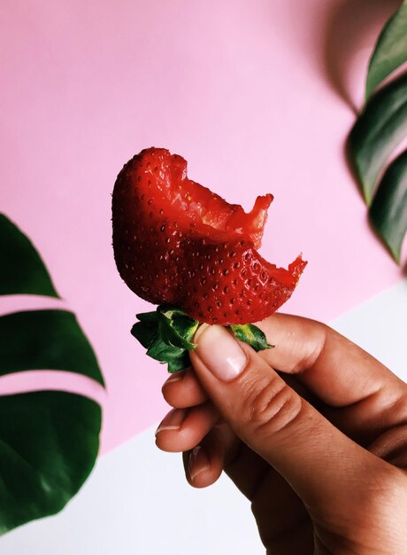 Photo cropped hand holding strawberry