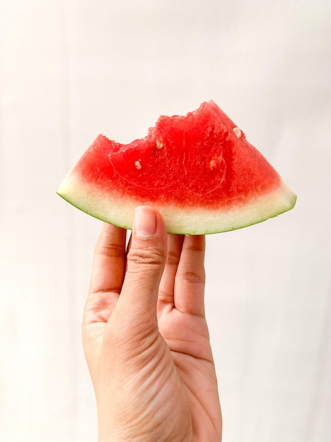 cropped hand holding watermelon slices