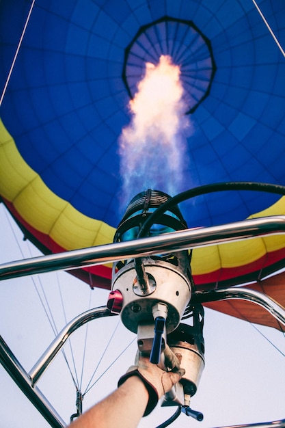 Foto mano tagliata di un uomo che vola in una mongolfiera