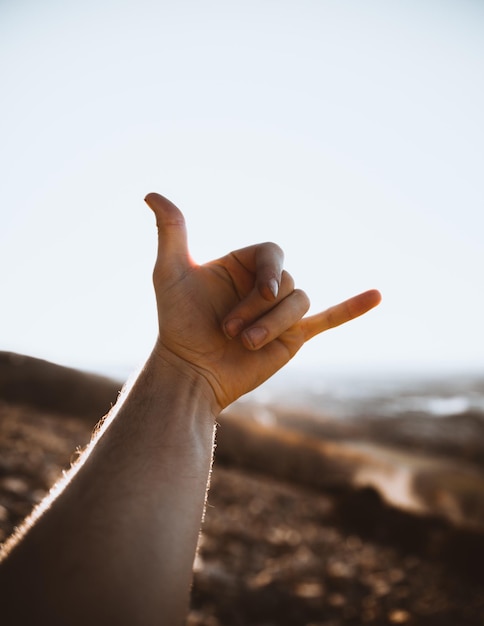 Photo cropped hand of man gesturing against sky