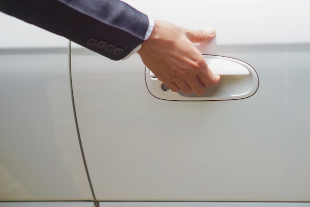 cropped hand of man holding car door handle