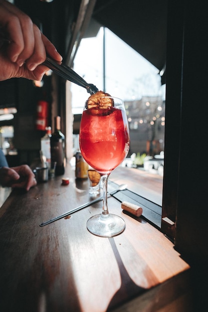 Photo cropped hand of man holding drink on table